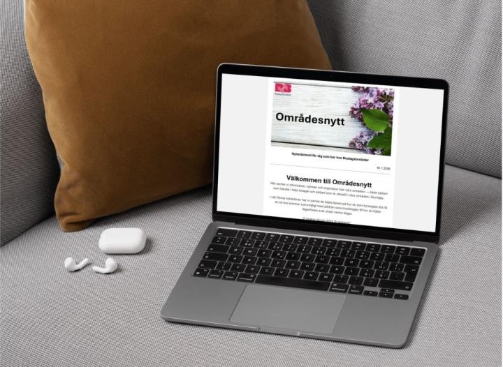 Dator i en soffa som visar nyhetsbrevet Områdesnytt på skärmen