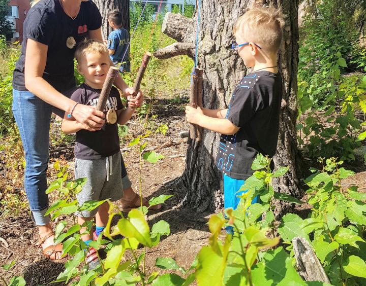 Två pojkar i 5-årsåldern som leker i skogsbrynet på sommarlovsdagarna.